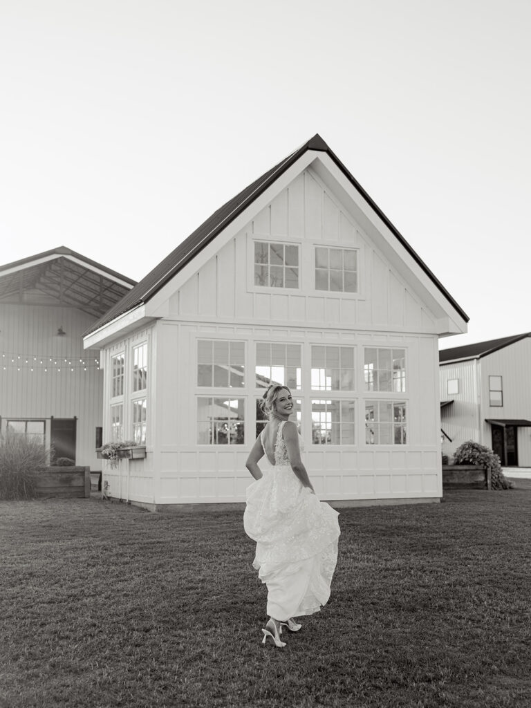 black and white photo of bride walking away towards little white chapel during session at davis and grey farms