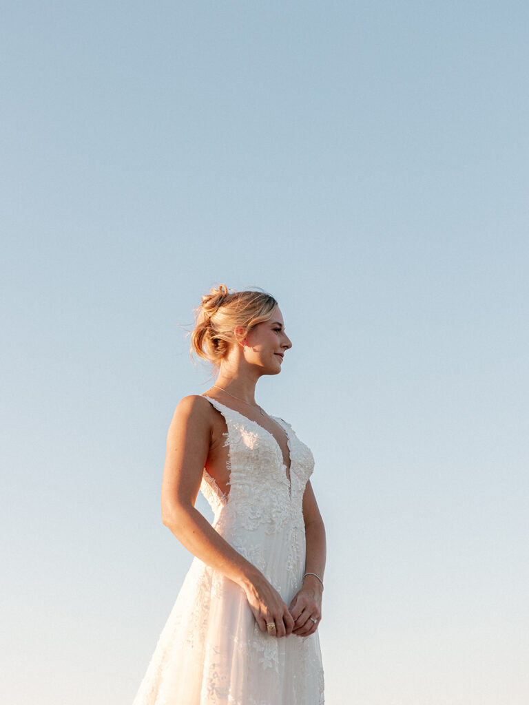 bride looking off in the distance with the blue sky as the background