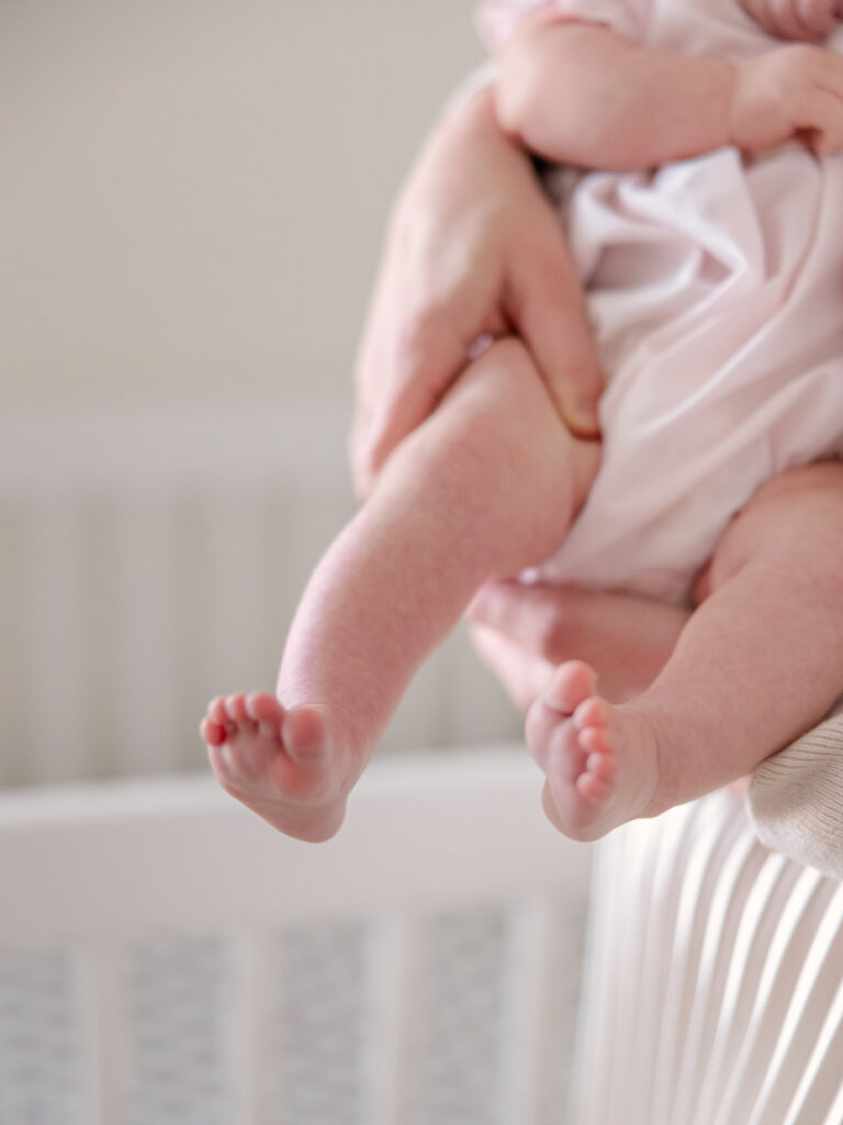 newborn toes and leg while mom holds her