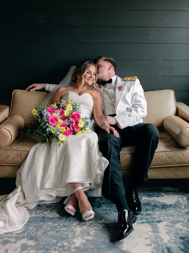 bride and groom sitting on a couch in groom suite