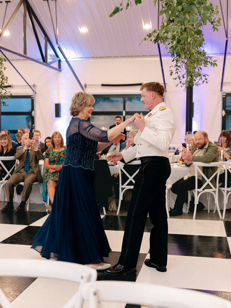 groom and mother of the groom dancing at the wedding reception at davis & grey farms