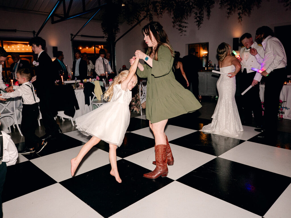 flower girl dancing with wedding guest on dance floor during wedding at Davis & Grey Farms