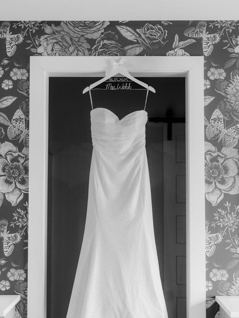 brides dress hanging on a custom wedding day hanger that says her new name Mrs Webb