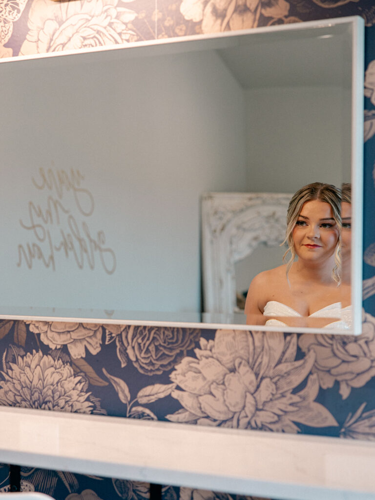 bride admiring herself in the mirror after getting ready in the bridal suite for her wedding at Davis & Grey Farms