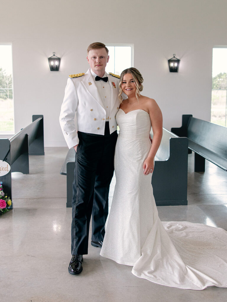 bride and groom posed for a photo in the indoor chapel during their wedding at Davis & Grey Farms