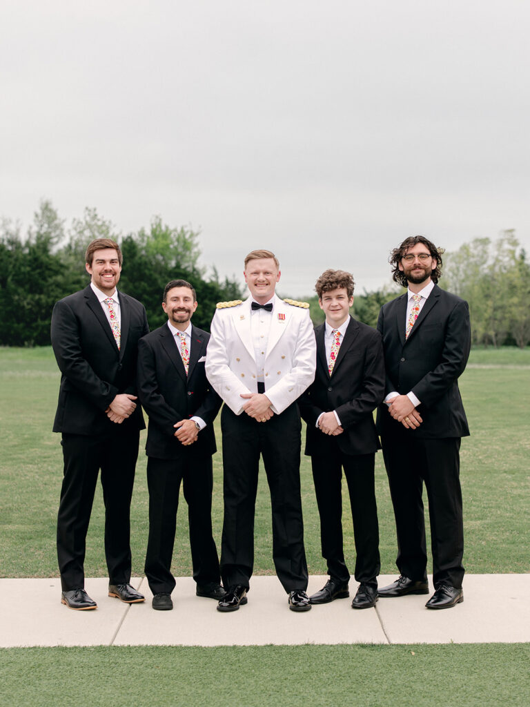 groomsmen and groom standing together outside during the wedding at Davis & Grey Farms