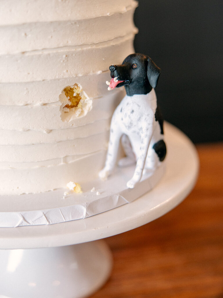 dog figurine replica with what looks like a dog bite out of the wedding cake