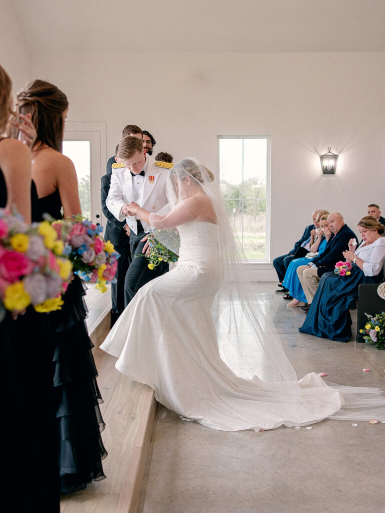 groom leading bride up the altar stairs for their wedding at Davis & Grey Farms