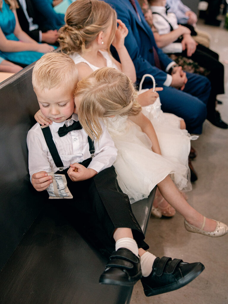 flower girl kissing the ring bearer hugging each other during the ceremony for the wedding at Davis & Grey Farms