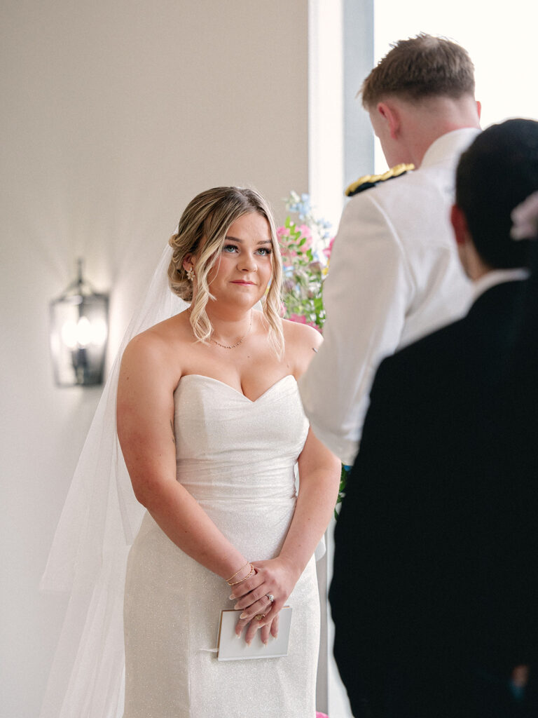 Bride gazing lovingly at her groom at the altar