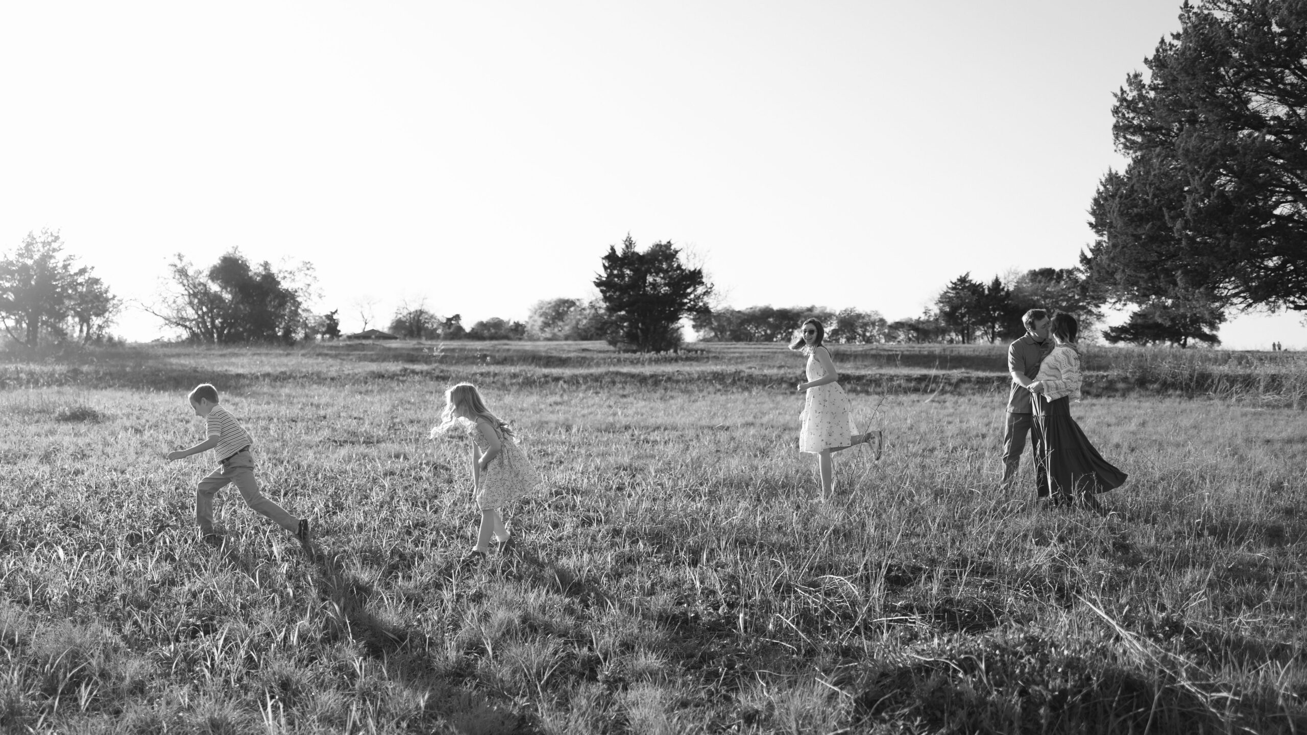 prepare kids for photoshoot by making it fun and having family of 5 running through a field together