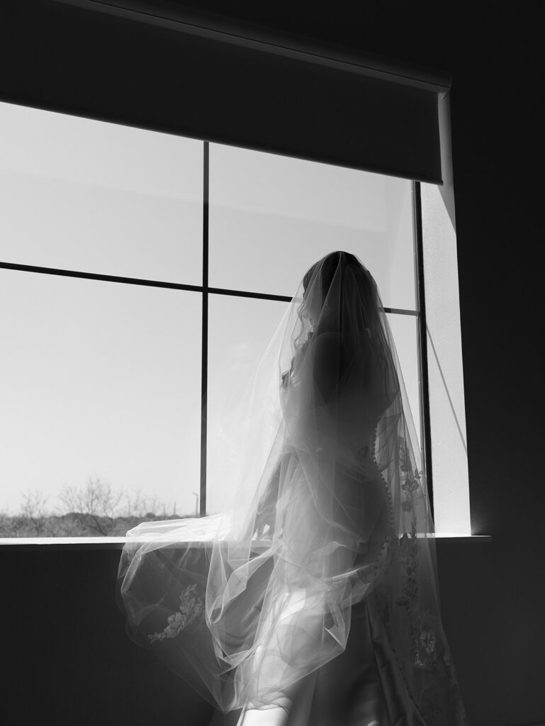 Bride looking out a window during a bridal session