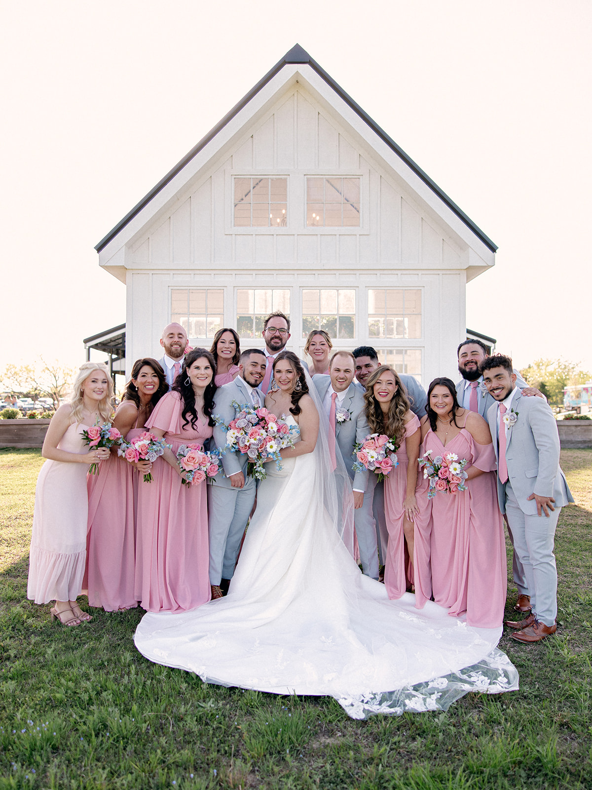 Bride and Groom with their wedding party after the ceremony outdoors at Davis and Grey Farm venue in Celeste, Texas.
