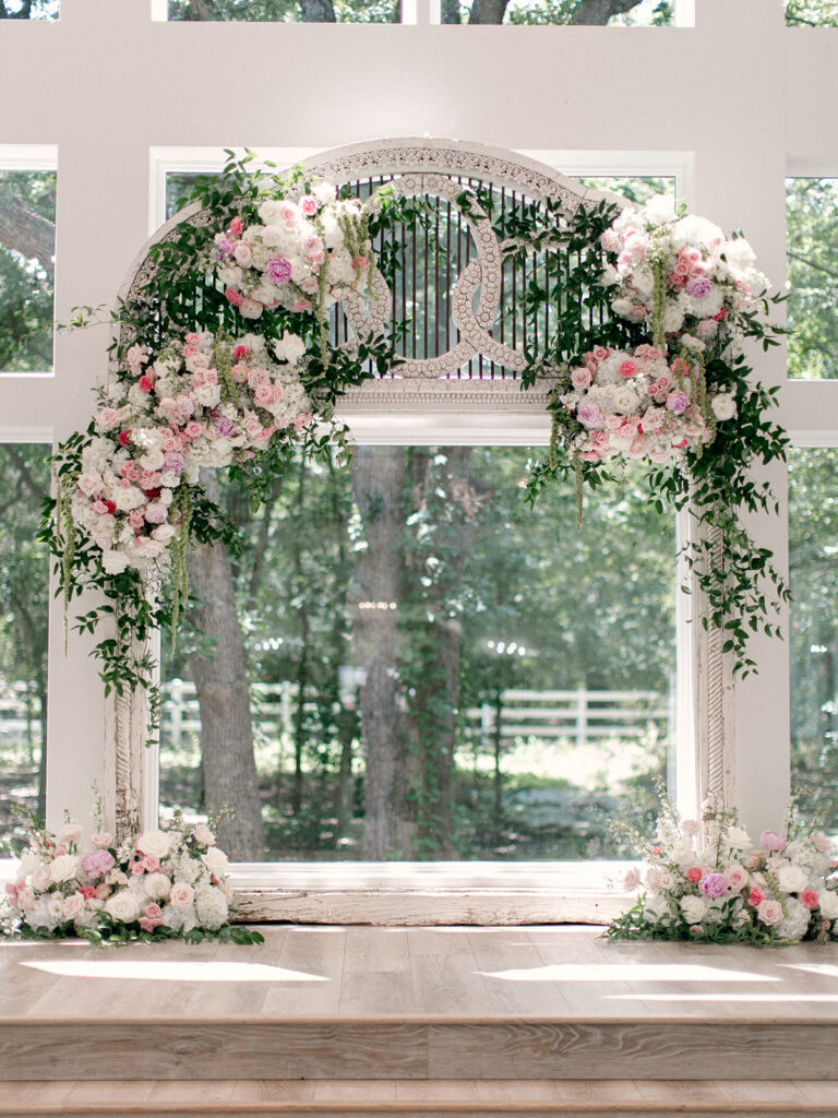 Pink and white floral wedding altar inside The French Farmhouse chapel