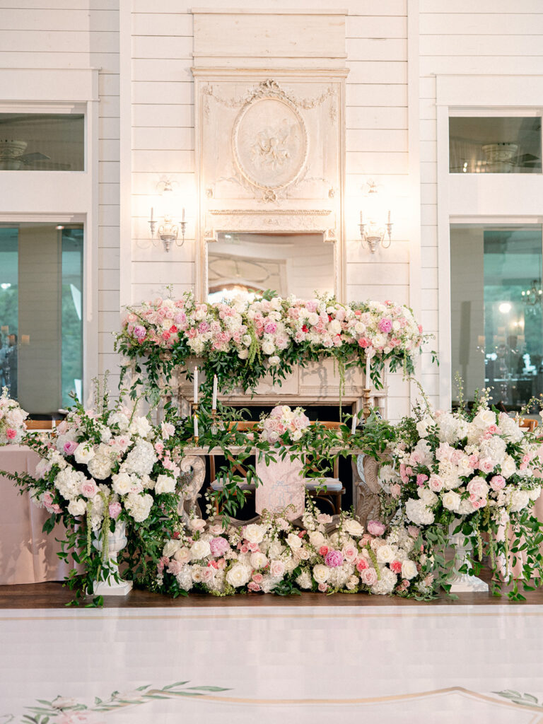 Pink and white floral installation around the fireplace by The Grand Poppy